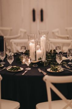 the table is set with candles, plates and silverware for an elegant wedding reception