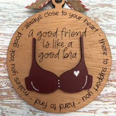 a wooden ornament that says, good friend is like a bra on it