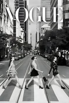 three women crossing the street in front of tall buildings, with the word'vogue'over them