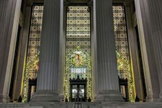 the inside of a building with columns and stained glass windows