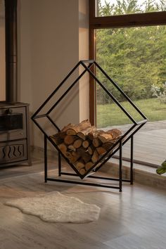 a stack of firewood sitting in front of a window next to a pile of logs