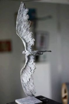 a white bird statue sitting on top of a table