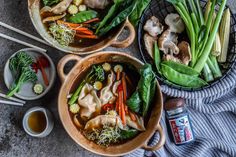 three bowls filled with soup and vegetables on top of a table