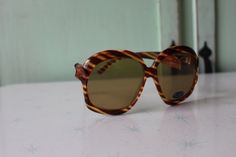 "1970s RARE Deadstock Sunglasses Glass Lenses- Impact Resistant Sticker still on lens Wonderful vintage condition Very rare deadstock Tinted Lens as seen in picture non-prescription amazing style Made in Taiwan 5.5\"total width 2 1/2\"lens width 5 1/4\"arms length Thank YOU and please feel free to ask me any ?s:) Have a lovely day xoxo www.etsy.com/shop/retroandme **on cardboard stand" Sunglasses 70s Vintage, 60s Sunglasses Vintage, Retro Brown Sunglasses With Mirrored Lenses, Womens Eyewear, Cardboard Stand, Vintage Plastic Sunglasses With Tinted Lenses, Girl Sunglasses, Mid-century Brown Tinted Sunglasses, 4 Arms