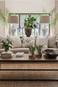 a living room filled with lots of furniture and plants on top of a coffee table