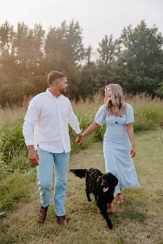 a man and woman holding hands with a dog