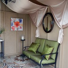 a green couch sitting under a canopy in a room