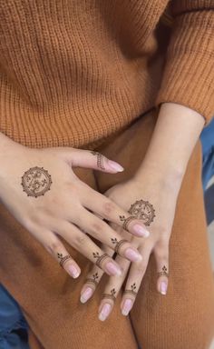 a woman's hands with tattoos on them