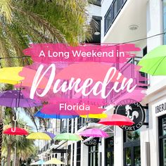 a sign that says a long weekend in queendix florida with colorful umbrellas hanging from it