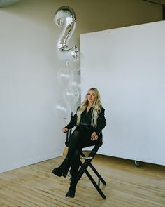 a woman sitting in a chair next to a balloon