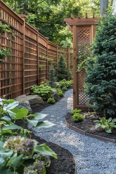 A serene garden walkway with wooden lattice fencing, lush plants, small trees, and a gravel path winding through under dappled sunlight. Outdoor Privacy Trellis, Secret Garden Ideas Diy Small Spaces, Small Garden Ideas Front Of House, Small Yard Privacy, Outside Privacy Wall Ideas, Privacy Flowers, Side Yards Ideas Narrow, Outside Wall Ideas, Privacy With Plants