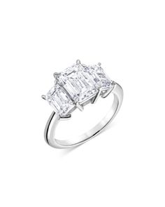 an emerald cut diamond ring with three baguets on the shoulders, set in 18k white gold