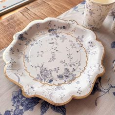 a blue and white plate sitting on top of a table next to a glass cup