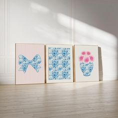 three framed pictures with flowers and bows on them in front of a white wall next to a wooden floor