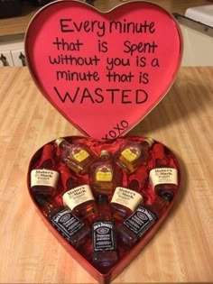 a heart shaped box filled with miniature bottles and an inscription on the inside saying every minute that is spent without you is a minute that is wasted