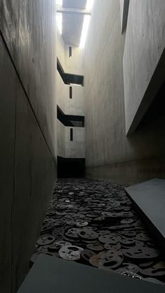 an empty hallway with black and white designs on the floor next to a stairwell way