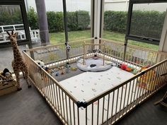 a baby's room with a giraffe in the window and toys on the floor