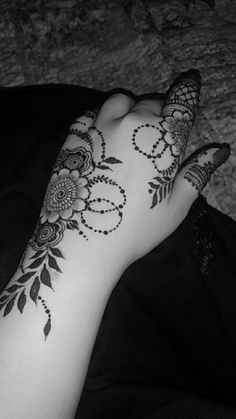 a woman's arm with hendix and flowers tattooed on the top of it