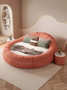 an orange round bed sitting on top of a wooden floor next to a white rug