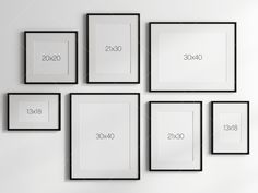 a white wall with black framed pictures on it and numbers in the frames above them