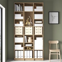 a room with a chair, bookshelf and several boxes on the shelves in it