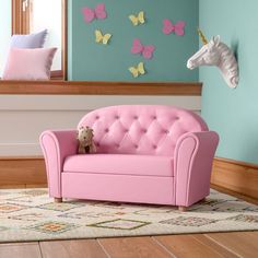 a pink couch with a stuffed horse on top of it