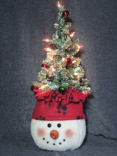 a small christmas tree in a snowman's hat