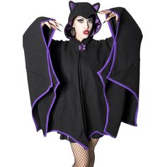 a woman dressed in black and purple is posing with her hands on her hips while wearing a bat costume