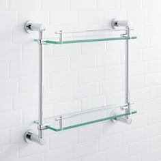 two glass shelves mounted to the wall with metal brackets on each side and one shelf above them