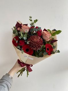 a person holding a bouquet of flowers in their hand