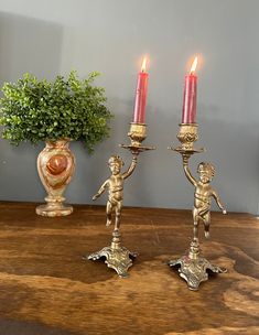 two candles are lit on a wooden table