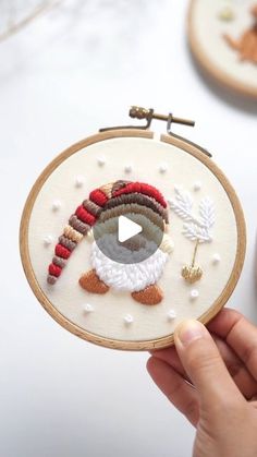 someone is holding up a small embroidery hoop with an image of a turkey on it