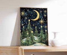 a night scene with stars and trees in the sky, framed on a wall above a table