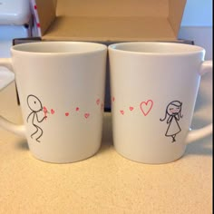 two coffee mugs with stick figures on them