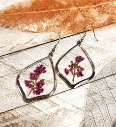 Real pressed Heather flower earrings sealed in resin. Nickel free earring hooks. Nature-inspired Teardrop Birth Flower Earrings, Nature-inspired Teardrop Earrings With Pressed Flowers, Silver Pressed Flower Resin Earrings, Silver Pressed Flower Earrings In Resin, Silver Resin Earrings With Pressed Flowers, Silver Teardrop Earrings With Pressed Flowers, Resin Teardrop Earrings For Gifts, Handmade Resin Teardrop Earrings As Gift, Hypoallergenic Flower Teardrop Earrings For Gift