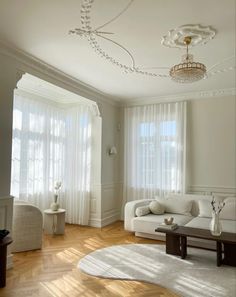 a living room filled with furniture and white curtains