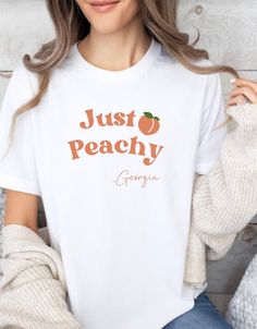 Georgia 'Just Peachy' T-Shirt - Southern Charm Tee, Peach State Pride, Casual Georgia Top, Fun Fruit Graphic Shirt, Souvenir Comfort Wear .: Made with 100% Airlume combed and ring-spun cotton, a lightweight fabric (4.2 oz/yd² (142 g/m that is easy to layer, breathable. Perfect for active and leisure wear.  .: The retail fit that is perfect for casual and semi-formal settings. The crew neckline adds a classic, neat style that's perfect for accessorizing. .: Bella+Canvas manufactures all its products in the US and internationally in humane, no-sweat-shop, sustainable way and is part of the Fair Labor Association as well as Platinum WRAP certified.   .: The tear-away label minimizes skin irritations. .: Fabric blends: Ash and Heather Prism colors - 99% Airlume combed and ring-spun cotton, 1% Cute Peach T-shirt With Crew Neck, Cute Peach T-shirt With Graphic Print, Heather Peach Letter Print Crew Neck Top, Heather Peach Graphic Print Crew Neck T-shirt, Cute Peach Crew Neck T-shirt, Cute Peach T-shirt With Letter Print, Peach Graphic Tee Short Sleeve, Peach Short Sleeve Graphic Tee, Peach Graphic Tee With Short Sleeves