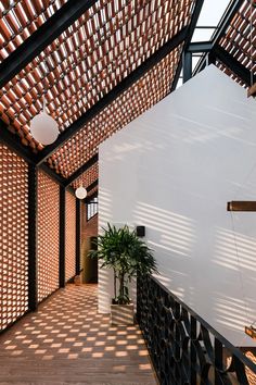 the inside of a building with wooden slats on the walls and ceiling, along with a potted plant