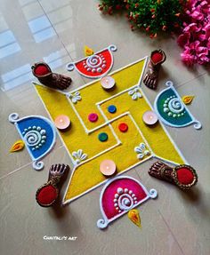 an artistically designed rangolite design on the floor with flowers in the background