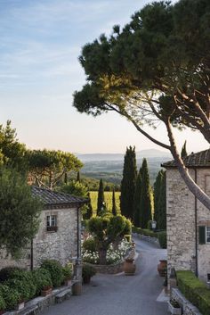 an outdoor area with stone buildings and trees in the foreground, surrounded by greenery