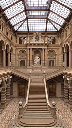 the inside of a large building with many stairs and windows on each side of it