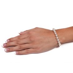 a woman's hand wearing a bracelet with pearls