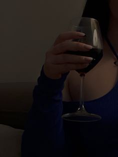 a woman holding a wine glass in her right hand