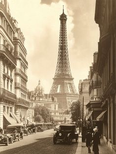 an old photo of the eiffel tower in paris with people walking down the street