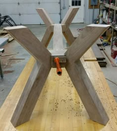 a wooden table with an orange pipe sticking out of the center and two pieces of wood sitting on top of it