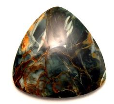 a large green and brown stone sitting on top of a white surface