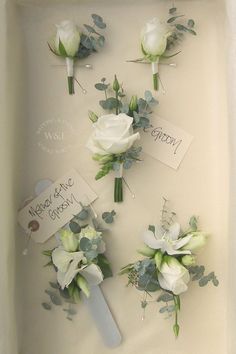 wedding boutions in a white box with greenery