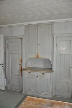 an old kitchen with white cupboards and wood flooring