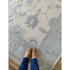 a person standing on top of a rug with their feet propped up against the carpet