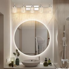 a bathroom with a round mirror above the sink and lights on the wall behind it